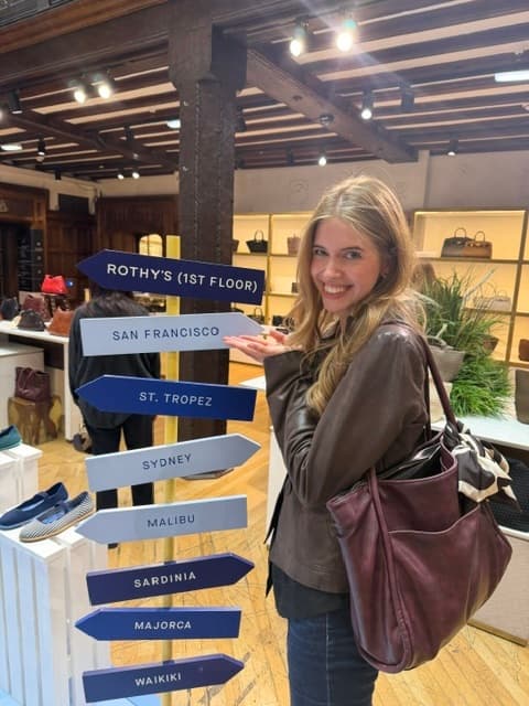 Smiling next to a signpost of destinations